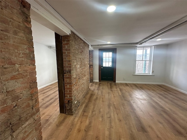 foyer with hardwood / wood-style flooring and brick wall