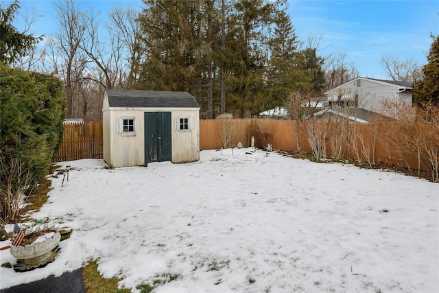 yard layered in snow featuring a storage unit