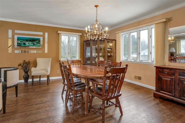 dining space featuring ornamental molding, dark hardwood / wood-style floors, and a chandelier