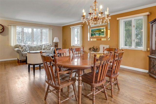 dining space featuring crown molding, a wealth of natural light, and light wood-type flooring