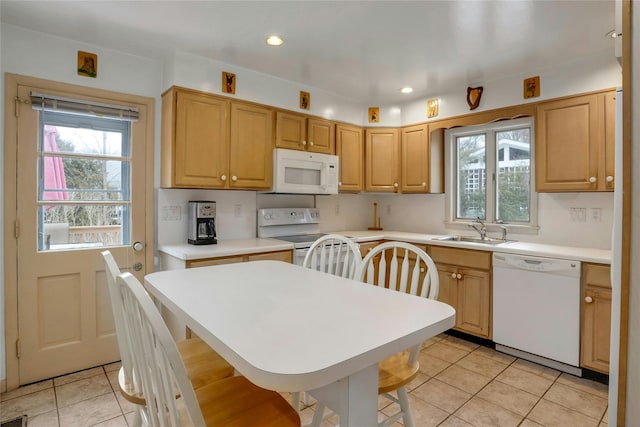 kitchen with sink, white appliances, light tile patterned floors, and light brown cabinets