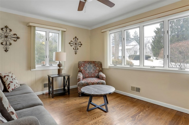 sitting room featuring ceiling fan, ornamental molding, a healthy amount of sunlight, and hardwood / wood-style floors