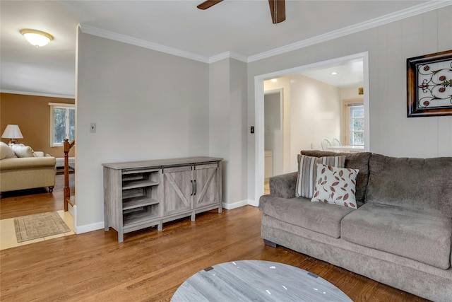 living room featuring crown molding, hardwood / wood-style floors, and ceiling fan