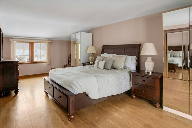 bedroom with lofted ceiling and light hardwood / wood-style flooring