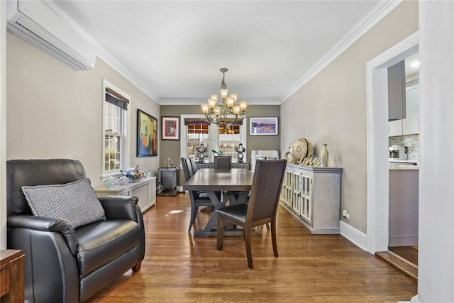 dining area featuring hardwood / wood-style flooring, ornamental molding, a chandelier, and a wall unit AC