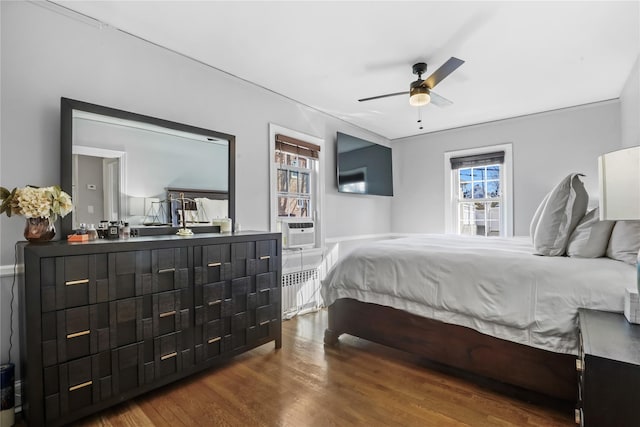 bedroom featuring hardwood / wood-style flooring, radiator heating unit, and cooling unit