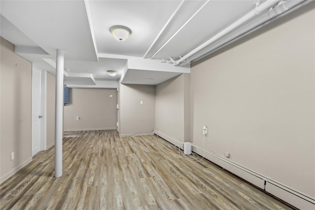 basement with baseboard heating and light hardwood / wood-style floors