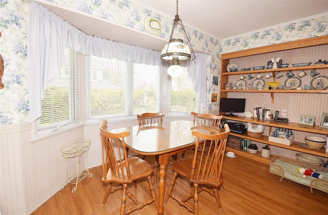 dining area with crown molding and hardwood / wood-style floors