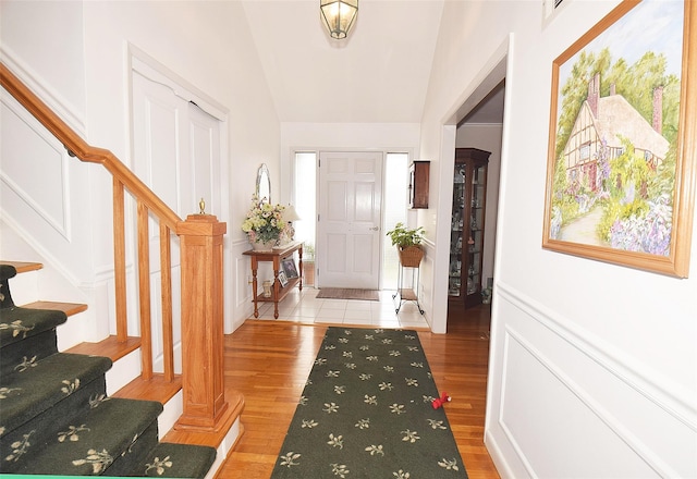 foyer with vaulted ceiling and light hardwood / wood-style floors