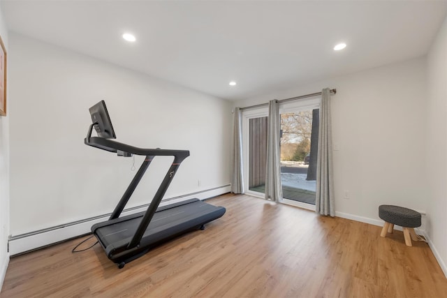 exercise area with baseboard heating and light hardwood / wood-style flooring