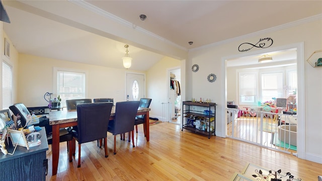 dining area with hardwood / wood-style flooring, crown molding, and a healthy amount of sunlight