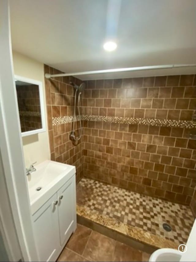 bathroom with vanity, tile patterned flooring, and tiled shower