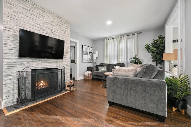 living room with dark hardwood / wood-style floors and a large fireplace