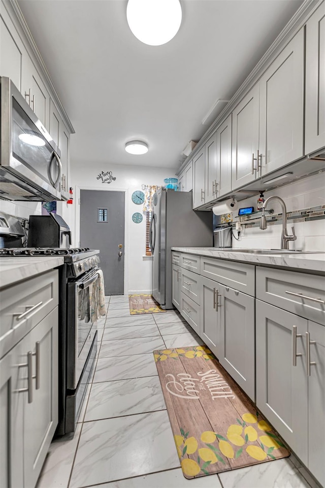 kitchen featuring appliances with stainless steel finishes, sink, and gray cabinetry