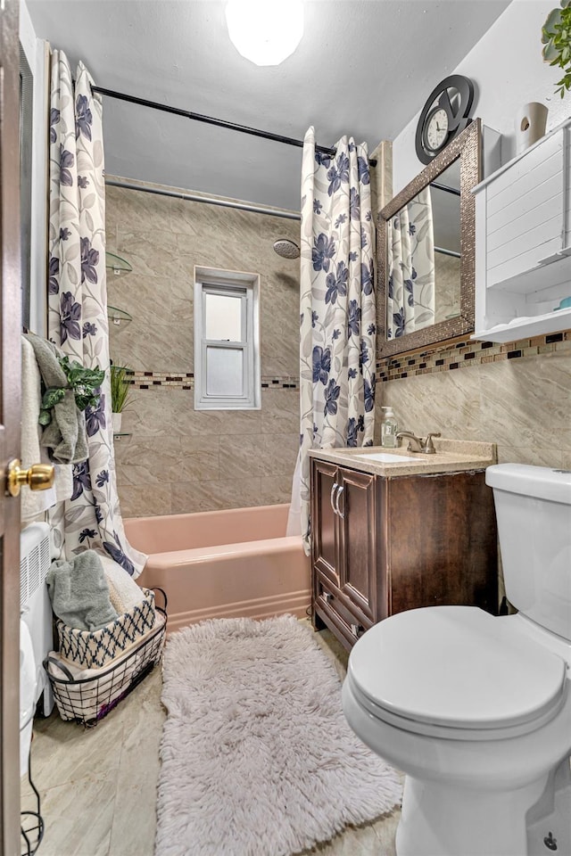 full bathroom featuring vanity, toilet, tile walls, and shower / bath combo