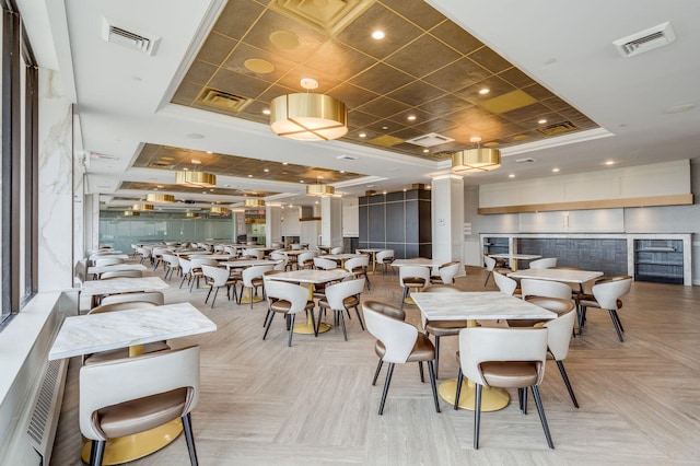 dining area featuring light parquet flooring and a tray ceiling