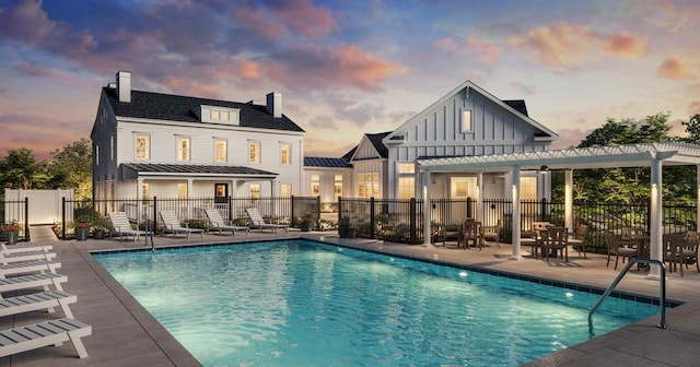 pool at dusk featuring a pergola and a patio