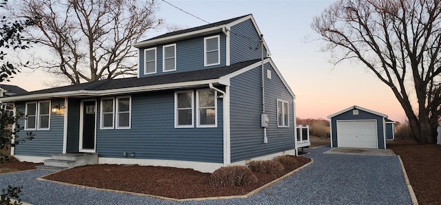 view of front of home with a garage and an outbuilding