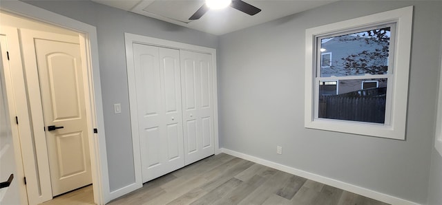 unfurnished bedroom with ceiling fan, a closet, and light wood-type flooring