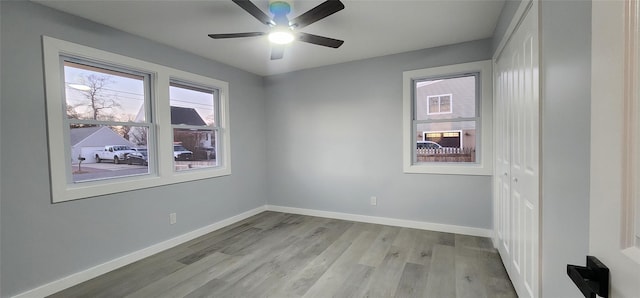 empty room with ceiling fan and light hardwood / wood-style floors