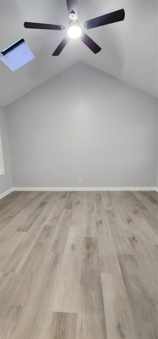 additional living space featuring lofted ceiling with skylight, ceiling fan, and light wood-type flooring