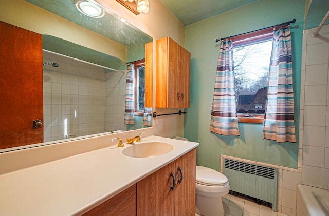 bathroom with tile patterned floors, toilet, radiator, and vanity