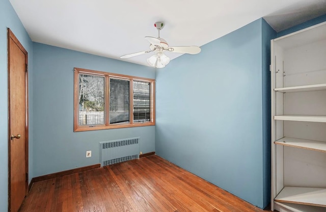 unfurnished bedroom featuring wood-type flooring and radiator