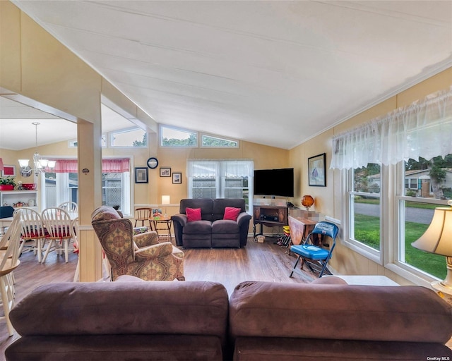 living room featuring vaulted ceiling, light hardwood / wood-style floors, a chandelier, and a healthy amount of sunlight