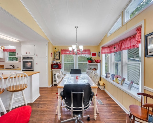 dining area with lofted ceiling, dark hardwood / wood-style flooring, sink, and a notable chandelier