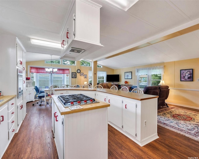 kitchen featuring white cabinetry, kitchen peninsula, vaulted ceiling, and a kitchen island