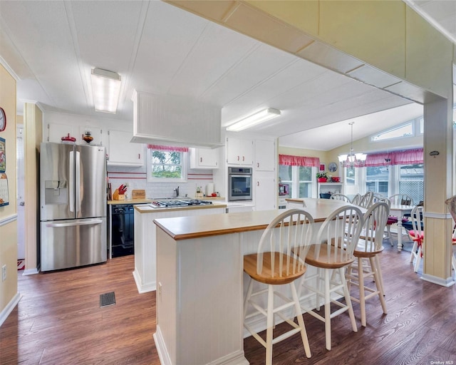 kitchen featuring stainless steel appliances, white cabinetry, a center island, and an inviting chandelier