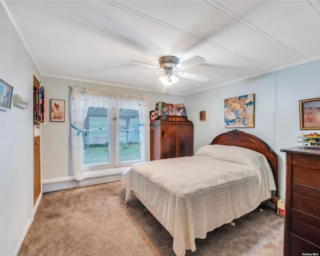 carpeted bedroom featuring ornamental molding and ceiling fan