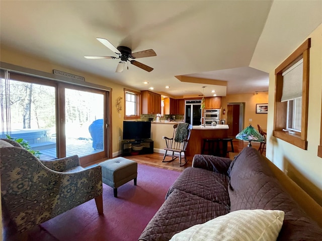 living room with ceiling fan and light hardwood / wood-style floors