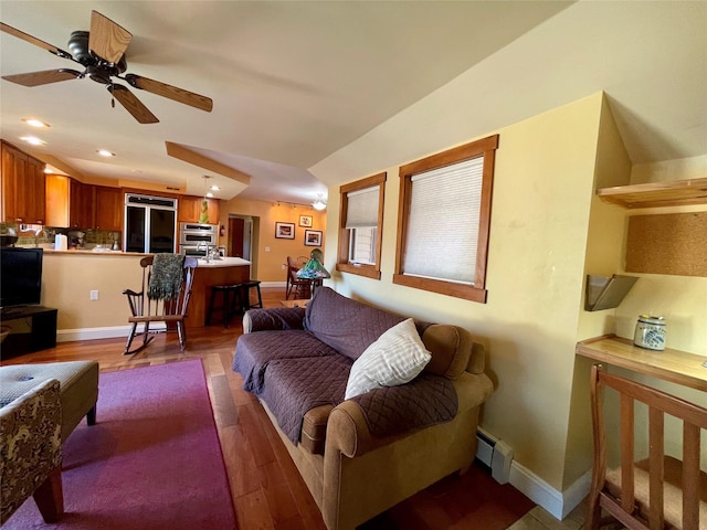 living room featuring baseboard heating, ceiling fan, lofted ceiling, and hardwood / wood-style flooring