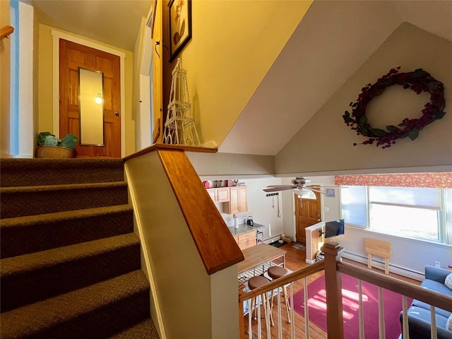 staircase with lofted ceiling, wood-type flooring, and ceiling fan