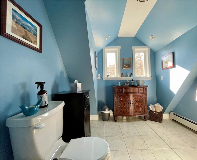 bathroom featuring lofted ceiling, a baseboard heating unit, and toilet