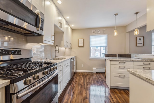 kitchen with sink, white cabinetry, decorative light fixtures, baseboard heating, and stainless steel appliances