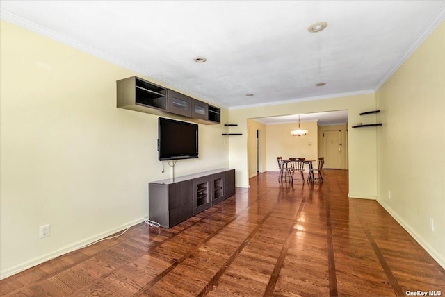 unfurnished living room with crown molding, dark hardwood / wood-style floors, and a notable chandelier