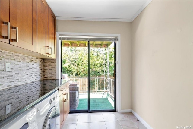 laundry room with crown molding, washer / dryer, and light tile patterned floors