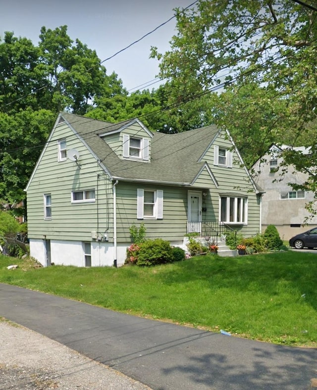 new england style home featuring a front lawn