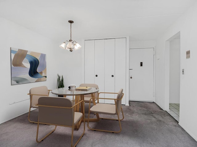 dining space featuring a chandelier and dark carpet