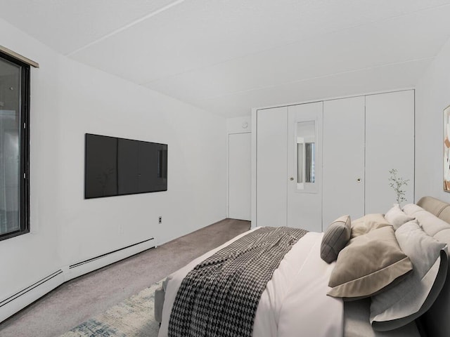 carpeted bedroom with a baseboard heating unit and a closet