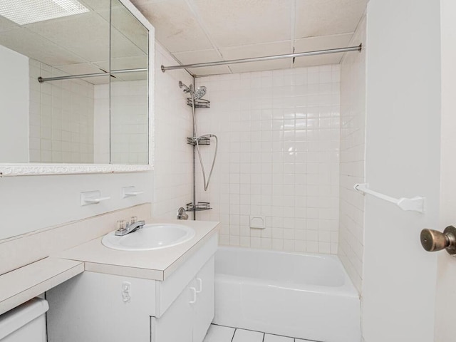 bathroom featuring tiled shower / bath combo, vanity, and tile patterned flooring