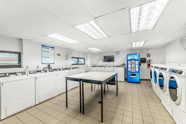 washroom with light tile patterned floors and washing machine and clothes dryer