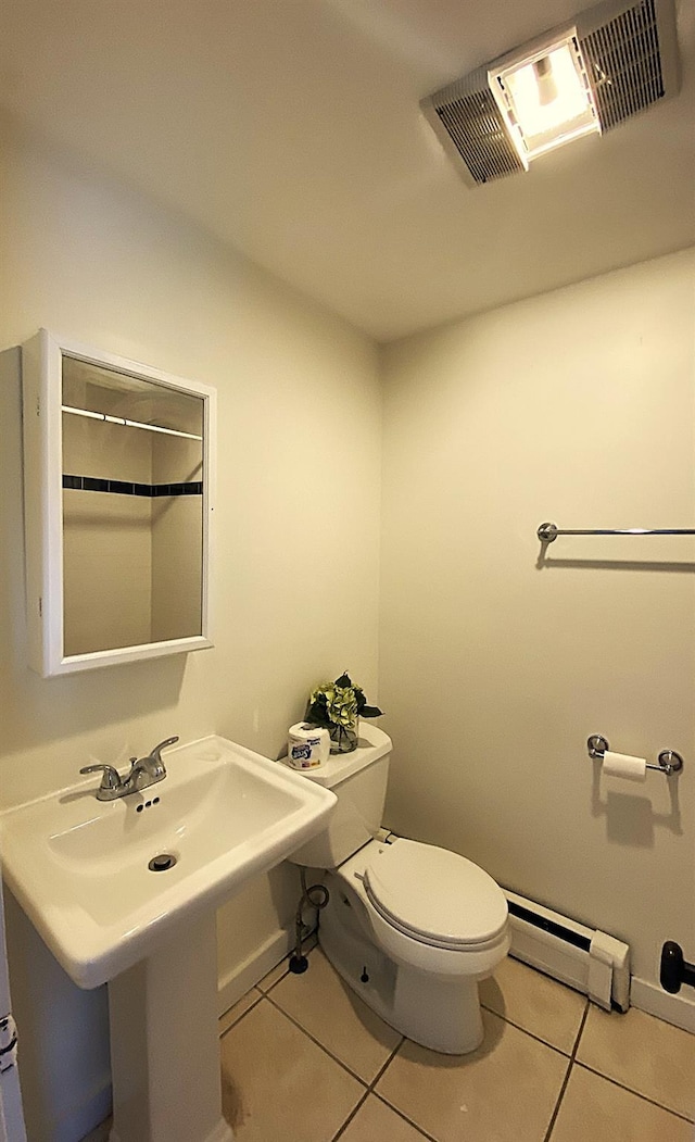 bathroom with baseboard heating, sink, toilet, and tile patterned flooring