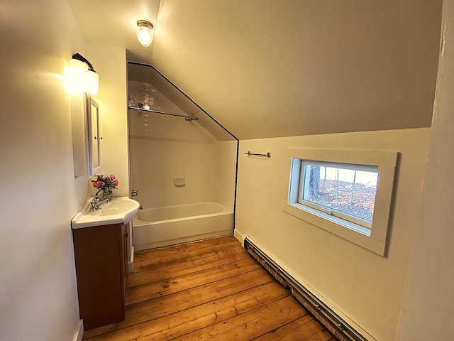 bathroom featuring vaulted ceiling, hardwood / wood-style floors, vanity, and a baseboard radiator