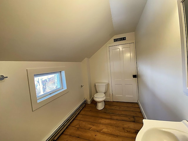 bathroom with hardwood / wood-style floors, vaulted ceiling, sink, and toilet