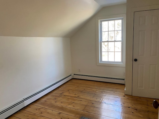 bonus room with lofted ceiling, a healthy amount of sunlight, light hardwood / wood-style floors, and baseboard heating