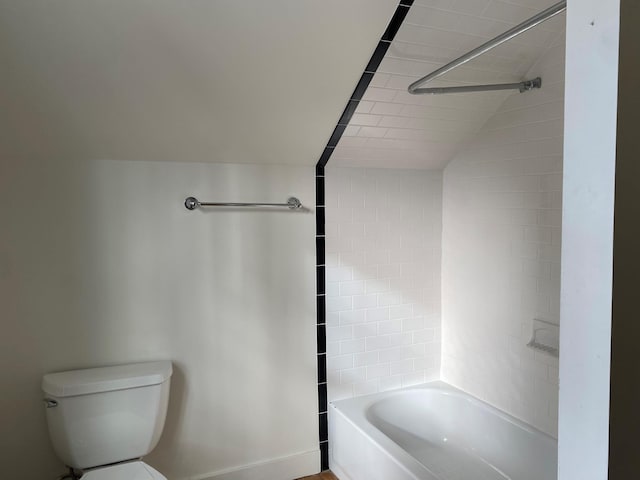 bathroom featuring tiled shower / bath and toilet