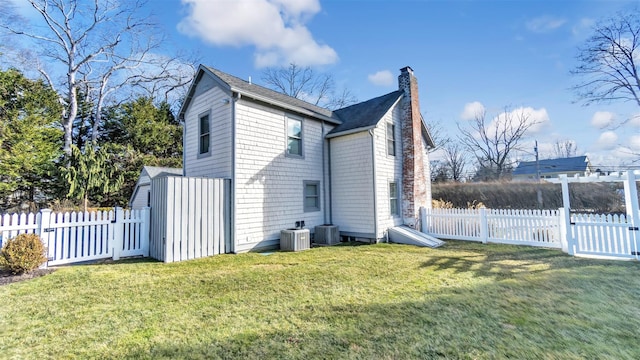 view of side of property with a yard and central AC unit